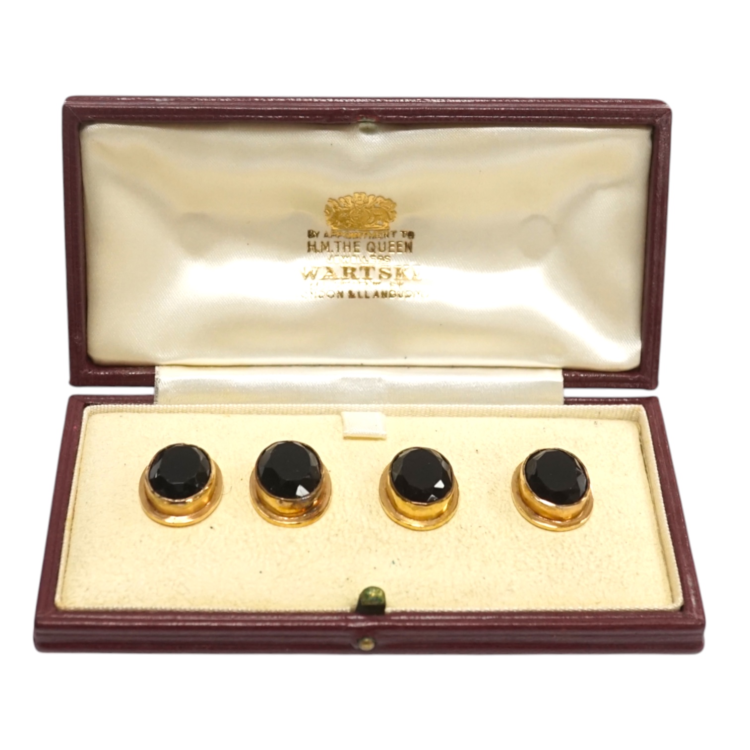 A set of four yellow metal and gem set oval buttons, 15mm, housed in a Wartski leather case. Condition - fair